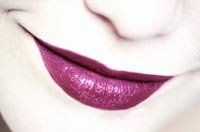 Lächelnde Lippen mit lila Lippenstift, Nahaufnahme.