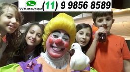 Palhaço sorridente com quatro crianças e uma pomba. Número de WhatsApp acima.