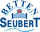 Logo von Betten Seubert mit blauer Brücke und rotem Stern.