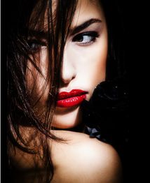 Frau mit roten Lippen und dunklen Haaren schaut seitlich, geheimnisvolle Stimmung.