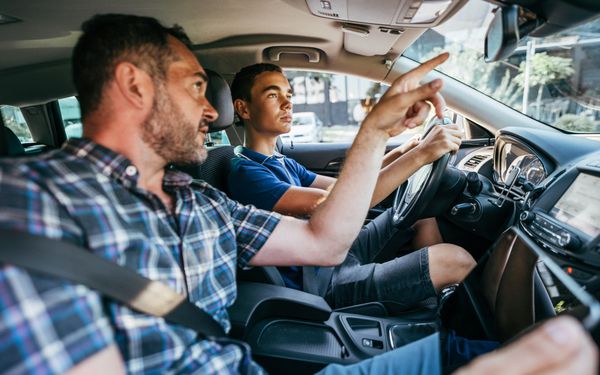 Fahrlehrer weist Schüler auf Rückspiegel