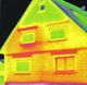 Thermografiebild eines Hauses mit unterschiedlichen Wärmezonen in Rot, Gelb und Grün.
