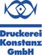 Blaues Logo mit stilisiertem Fisch und Text: Druckerei Konstanz GmbH.