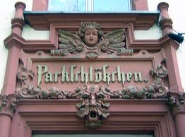 Ornamentaler Schriftzug "Parkschlösschen" mit Engelsgesicht über einer Tür.