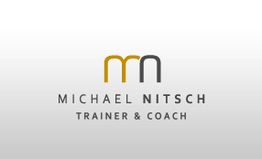 Logo mit Initialen "mn" und Text: "Michael Nitsch - Trainer & Coach", in Grau und Gold.