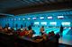 Bowlingbaan met mensen die bowlen; schermen boven de banen tonen scores.