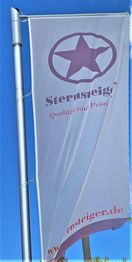 Weiße Fahne mit lila Stern und Text "Sternsteiger, Qualität und Präzision, sternsteiger.de".