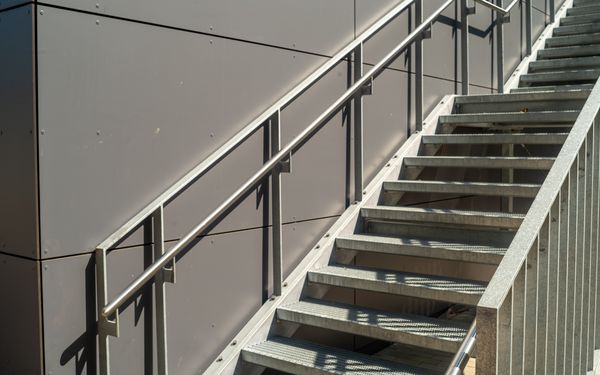 Metallaußentreppe an einer grauen Hauswand.