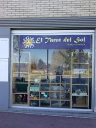 Escaparate de tienda "El Tarot del Sol" con productos esotéricos y decoración de sol.