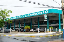 Terminal rodoviário de Balneário Camboriú com carros estacionados em um dia nublado.