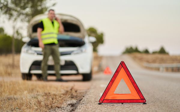 Mann hat eine Autopanne und kontaktiert Pannenservice