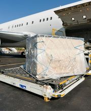 Carga siendo embarcada en avión de carga en el aeropuerto, con plataformas y contenedores.