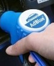 Mano inserisce erogatore blu di AdBlue in un serbatoio.