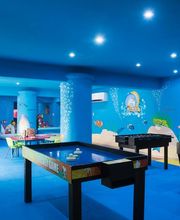 Sala de juegos temática marina, con mesas de billar y futbolín, paredes azules y decoración acuática.