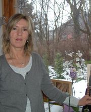 Eine Frau steht in einem Raum neben einem Kosmetikstand. Draußen liegt Schnee.