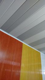 Teto cinza com parede dividida em faixas marrom, amarela e branca.