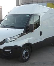 Furgoneta blanca estacionada en la calle frente a un edificio.