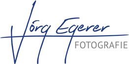 Logo mit handschriftlichem Text "Jörg Egerer" in Blau und "Fotografie" in Grau.