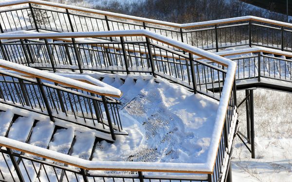 Metalltreppe an einem steilen Hang im Winter