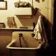 Vintage sink with hanging cloth and shelf above, in a dimly lit room.