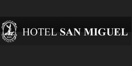 Logotipo del Hotel San Miguel en fondo negro con letras blancas y un emblema circular a la izquierda.