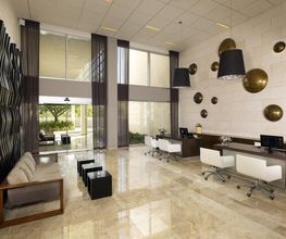 Espacio interior moderno con escritorios blancos, sofás y decoración en paredes.