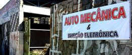Oficina de auto mecânica com placa anunciando serviços de injeção eletrônica.