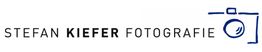 Logo mit Text "Stefan Kiefer Fotografie" und einer skizzierten Kamera rechts.