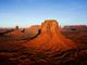 Rote Felsformationen im Monument Valley bei klarem Himmel und Sonnenschein.