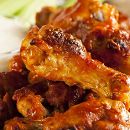 Close-up of crispy, golden-brown chicken wings on a plate.