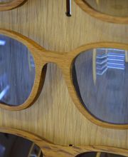 Gafas de sol de madera colgadas en una pared.