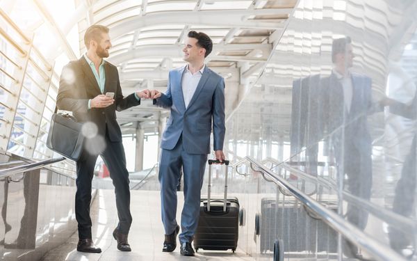 Zwei Kollegen am Flughafen auf Dienstreise.