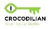 Grüner Schlüssellogo mit der Aufschrift "Crocodilian - Your Serviced Apartment Berlin".