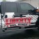 Black truck with a large "Liberty Bail Bonds" ad in red and white on its side.