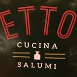 Logotipo com as palavras "ETTO Cucina Salumi" em letras vermelhas e brancas em fundo escuro.
