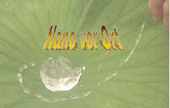 Grünes Blatt mit Wassertropfen und Text "Nano vor Ort", Finger oben rechts sichtbar.