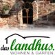 Backsteinwand mit Fenster und Blumenhalter, Logo „das landhus – Wohnen & Garten“ darunter.