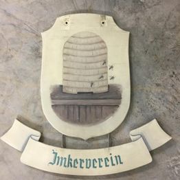 Wappen mit Bienenkorb und fliegenden Bienen, darunter ein Banner mit der Aufschrift "Imkerverein".