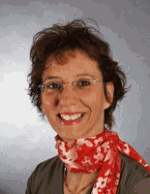 Frau mit Brille und rotem Halstuch lächelt vor grauem Hintergrund.