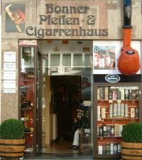 Außenansicht des Bonner Pfeifen- und Zigarrenhauses mit Schaufensterauslage und Deko-Pfeife.