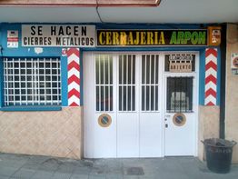 Fachada de cerrajería con carteles de "Se hacen cierres metálicos" y "Abierto".