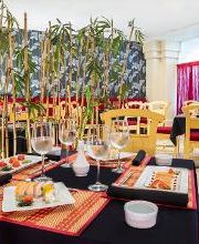 Restaurante elegante con mesas preparadas y decoración de bambú.