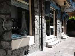 Vetrina di un negozio di abiti da sposa con facciata in pietra e tende blu sopra le finestre.