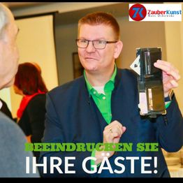 Mann in Anzug zeigt Trick mit Brieftasche. Text: "Beeindrucken Sie Ihre Gäste!"