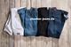 Fünf Jeanshosen in Weiß, Blau und Schwarz liegen auf Holzboden, mit "stooker-jeans.de" beschriftet.
