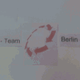 Text auf Schild: "IV - Team" und "Berlin" mit rotem Pfeilkreis in der Mitte.