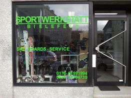 Schaufenster mit Skiausrüstung und grüner Schrift: "Sportwerkstatt Bielefeld - Ski Boards Service".