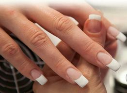 Nahaufnahme von Händen mit French Manicure. Weiße Spitzen auf den Fingernägeln.