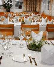 Elegantes Esszimmer mit gedecktem Tisch, weißen Servietten und vielen Gläsern.