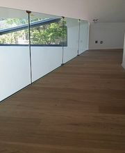 Holzboden, Glasgeländer, rechtwinklige Architektur in modernem Raum, Sonnenlicht durch Fenster.